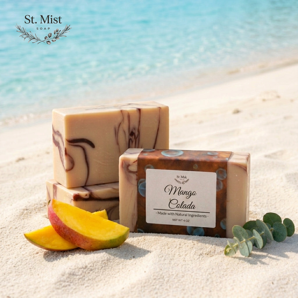 St. Mist Soap Mango Colada artisan soap bar with swirls on a sandy beach with fresh mango slices and eucalyptus.