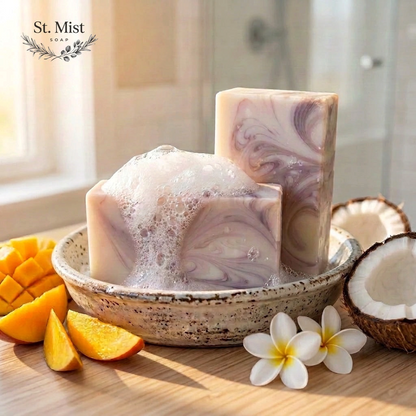St. Mist Soap Mango Colada artisan soap bar with creamy lather, mango slices, coconut, and plumeria flowers.